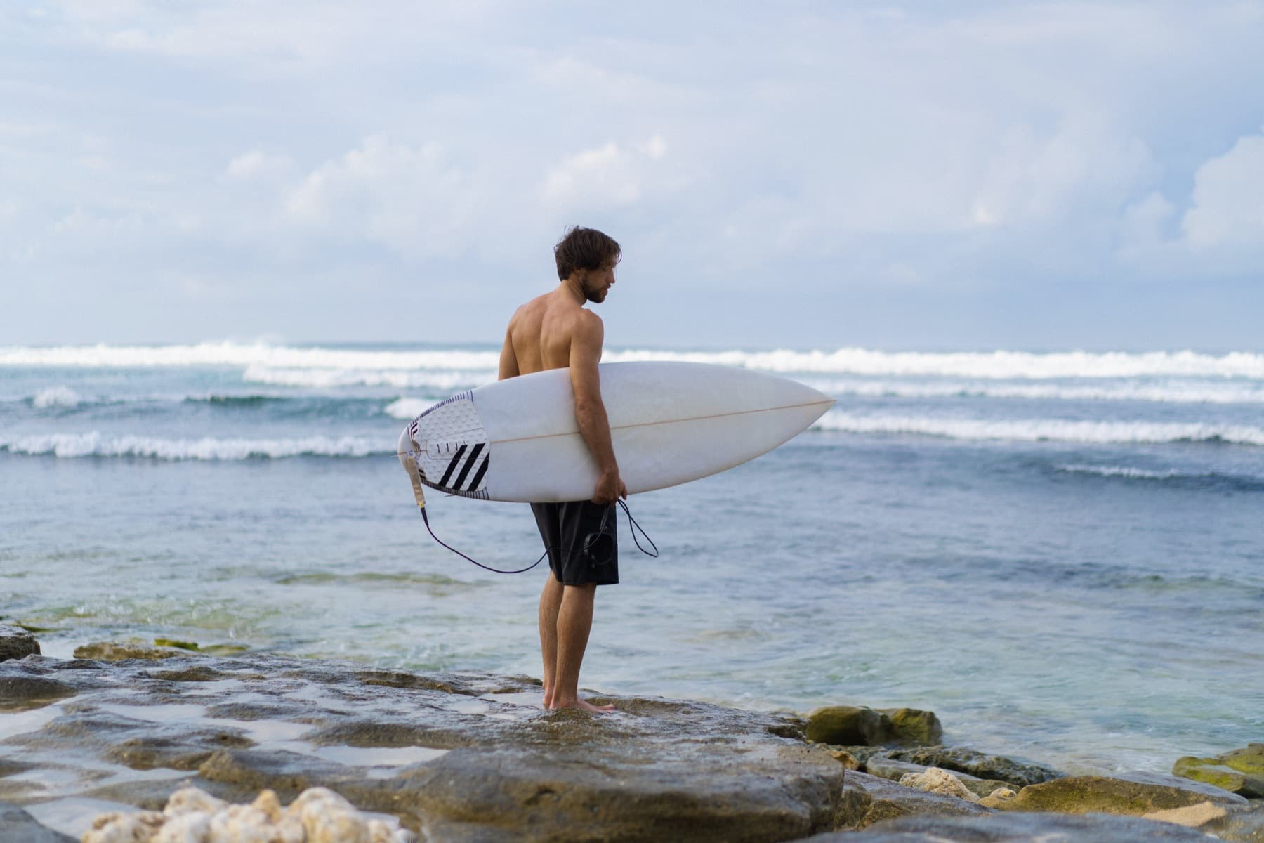Surfer with a board walking into the sea in Fuerteventura